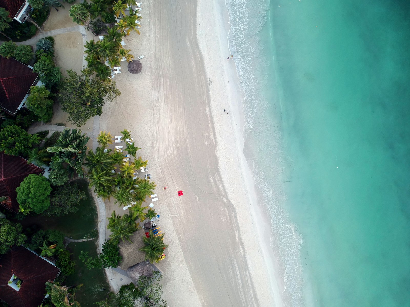 Aerial view of Seven Mile Beach in Negril, Jamaica, with palms, red roofs and turquoise water
